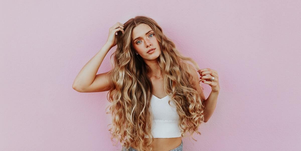 woman standing in front of pink wall